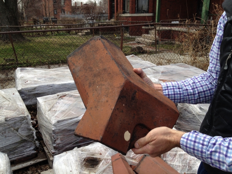 Jason holding a corner clay tile that will be used on our greenhouse roof.