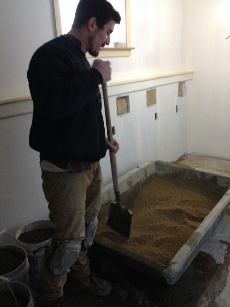 Mixing sand and cement for basement floor base