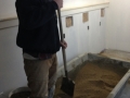Mixing sand and cement for basement floor base