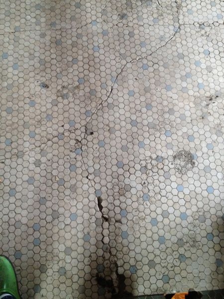 A cracked tile floor that will be repaired.