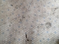 A cracked tile floor that will be repaired.
